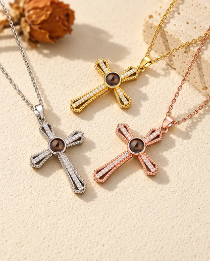 Croix argentée, dorée et couleur or rose à pierre brune près d'une dalle de travertin