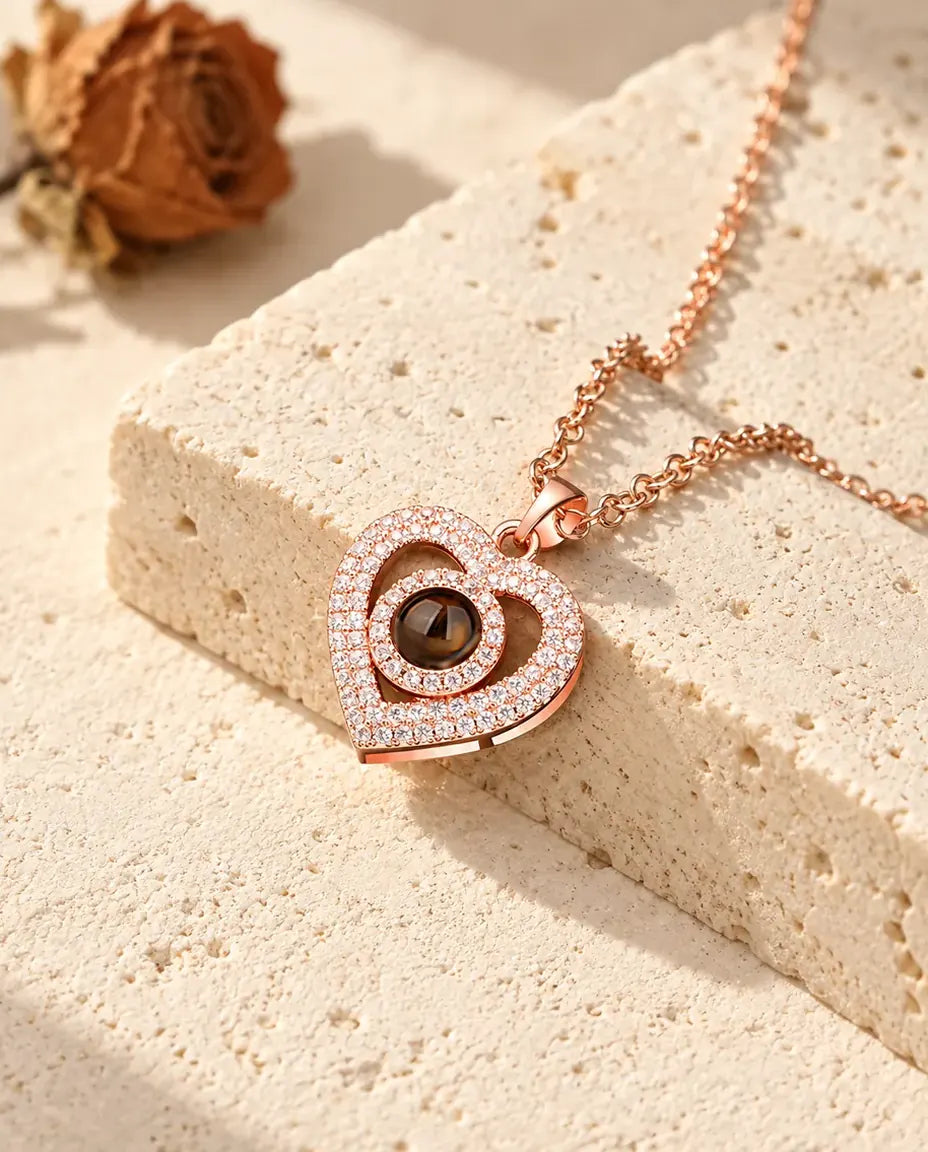 Pendentif double cœur couleur or rose pavé de zircons contre un bloc de travertin