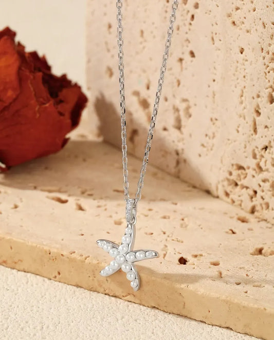 Collier Étoile de Mer en Argent 925 - pendentif suspendu au rebord d’une dalle de travertin