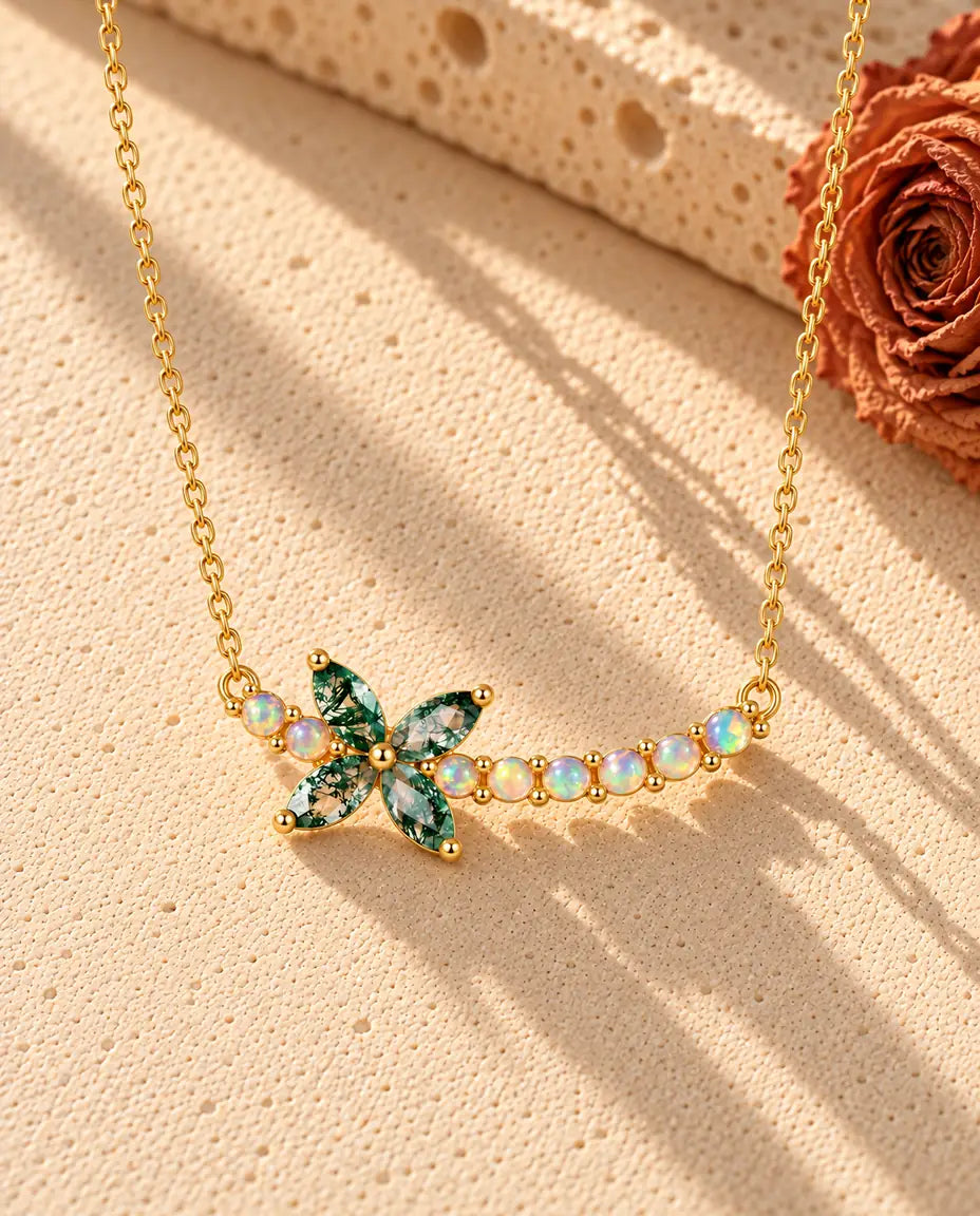 Collier Fleur Agate Mousse en Argent 925 Plaqué Or - posé sur une surface claire texturée près d’un bloc de travertin