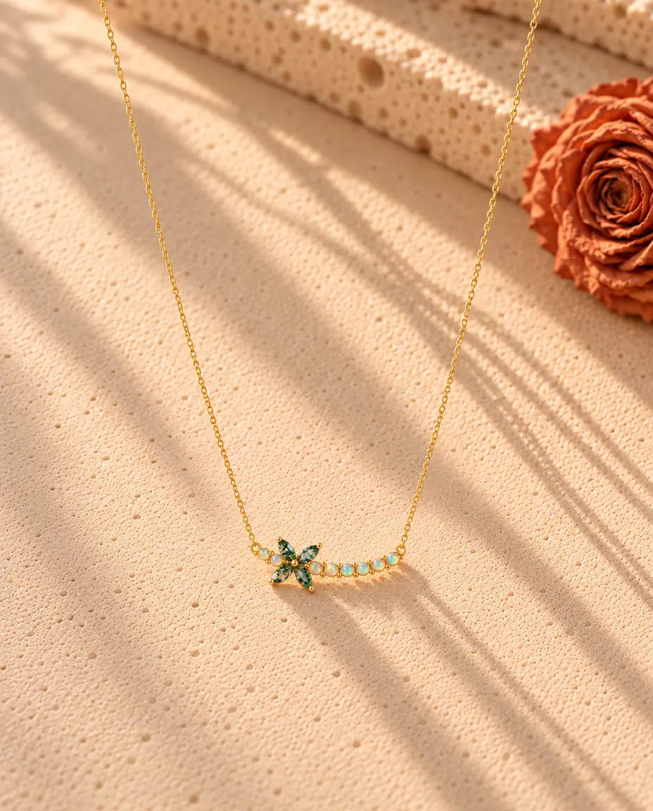 Collier Fleur Agate Mousse en Argent 925 Plaqué Or - le collier entier posé en long V sur une surface claire texturée