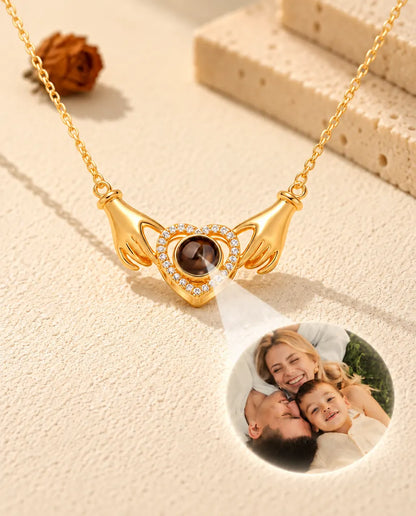 Lumière traversant la perle brune du collier doré aux mains et au cœur, révélant une photo de famille