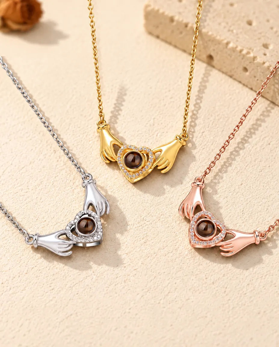 Les trois couleurs du collier photo projection mains et cœur alignées sur du plâtre crème