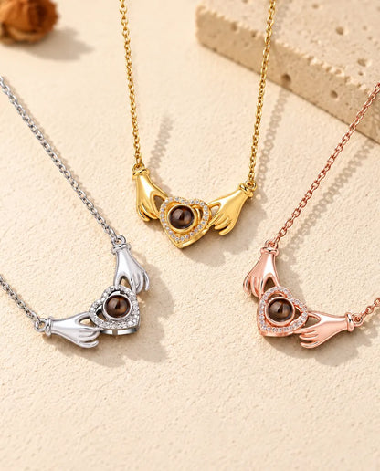 Les trois couleurs du collier photo projection mains et cœur alignées sur du plâtre crème