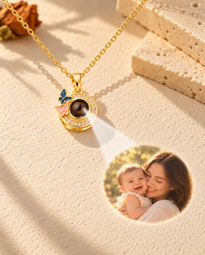 La lumière traverse la pierre du pendentif papillons doré et projette une mère avec son bébé