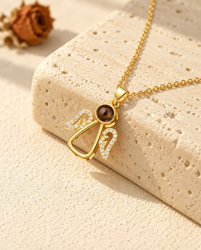 Collier ange doré aux ailes en zircons sur du travertin