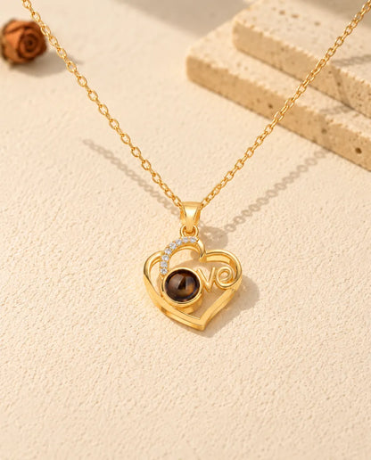 Pendentif cœur Love doré vu de face, la pierre de projection brune forme le o