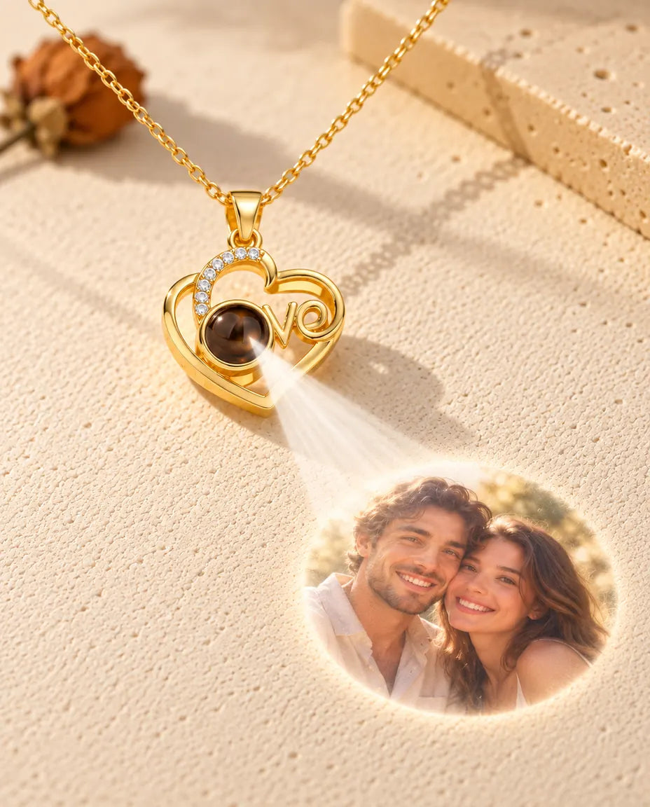 Collier cœur Love doré projetant une photo de couple depuis sa pierre sur du plâtre crème