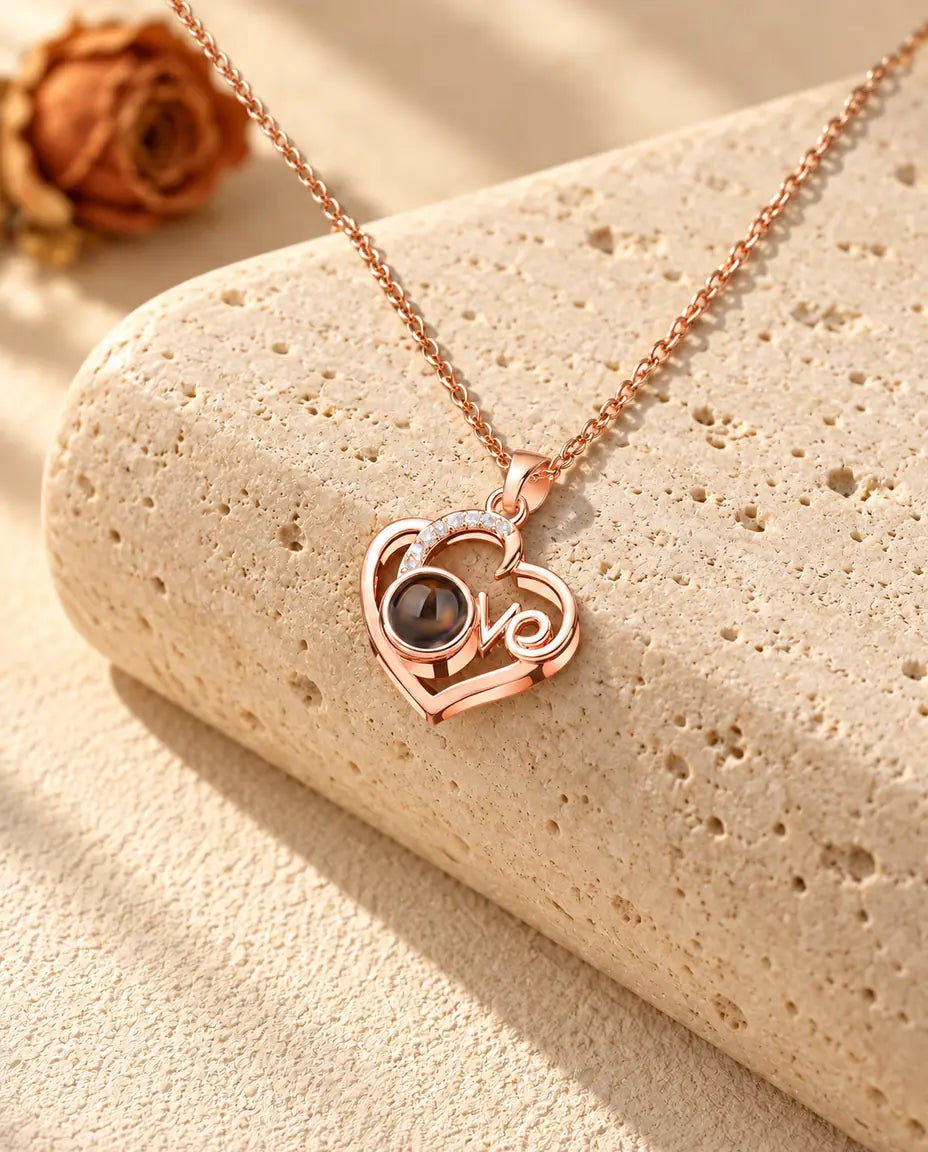 Collier photo projection cœur Love couleur or rose sur travertin au soleil chaud