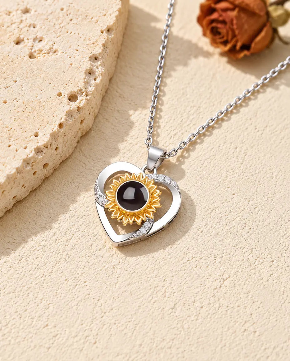Collier photo projection personnalisé : cœur avec tournesol doré posé sur du travertin