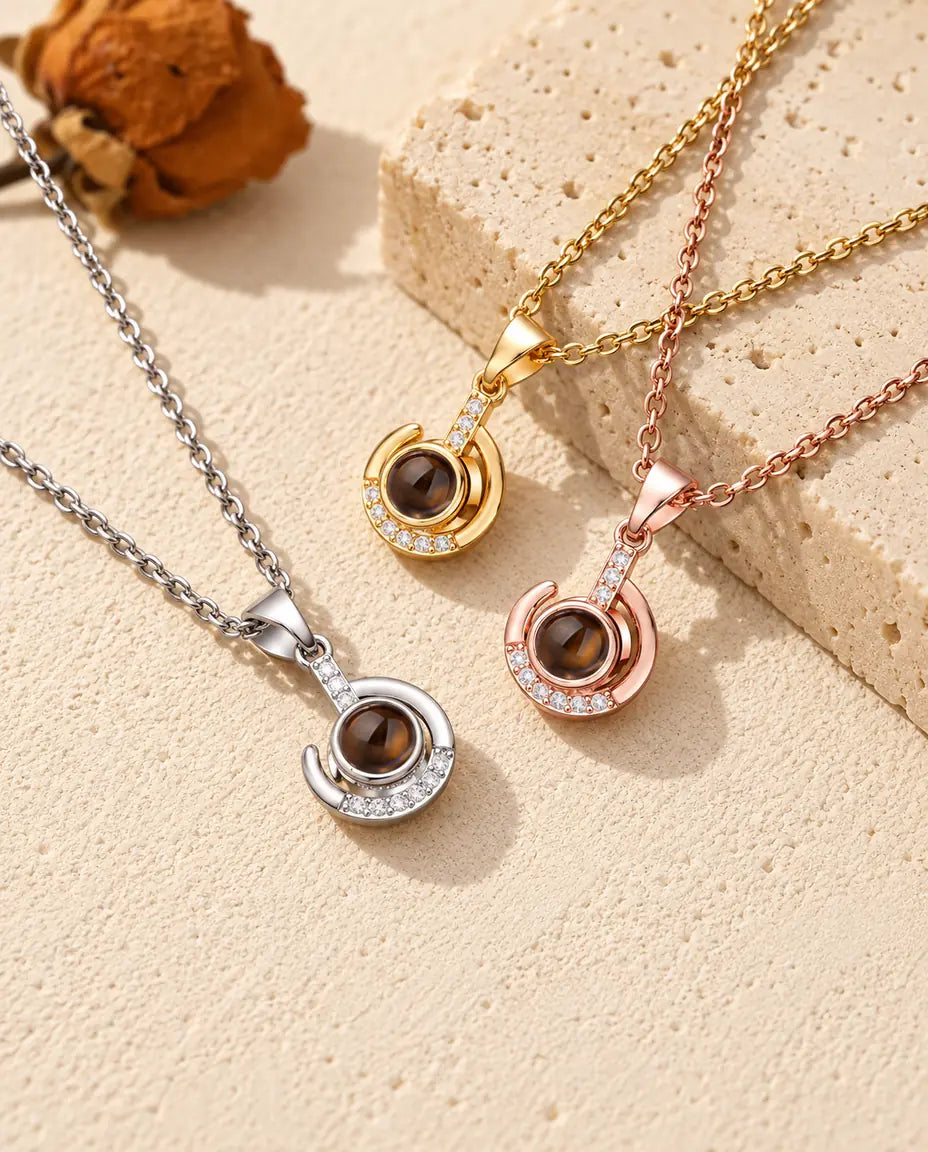 Pendentifs croissant enroulé argenté, doré et couleur or rose sur du travertin