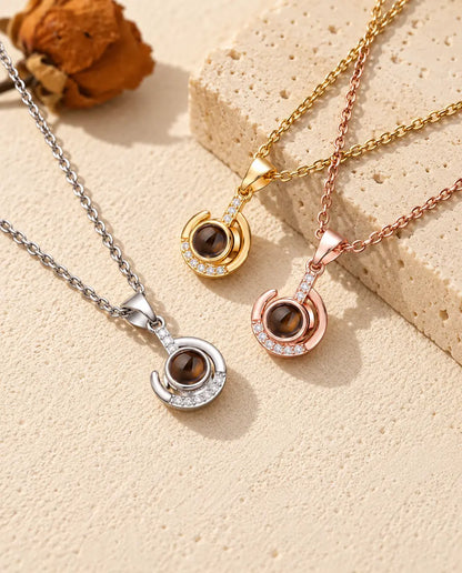 Pendentifs croissant enroulé argenté, doré et couleur or rose sur du travertin