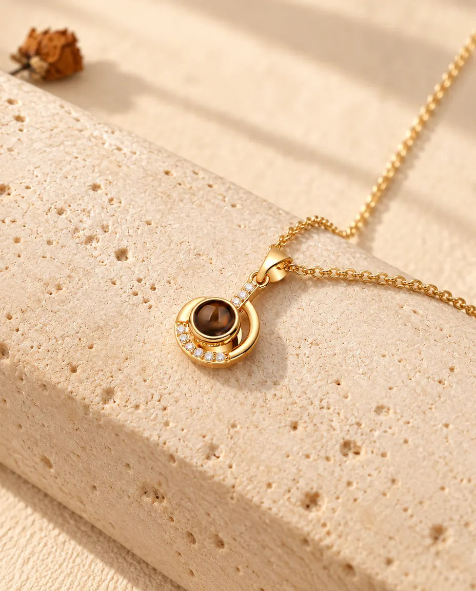 Collier croissant de lune doré posé sur un bloc de travertin