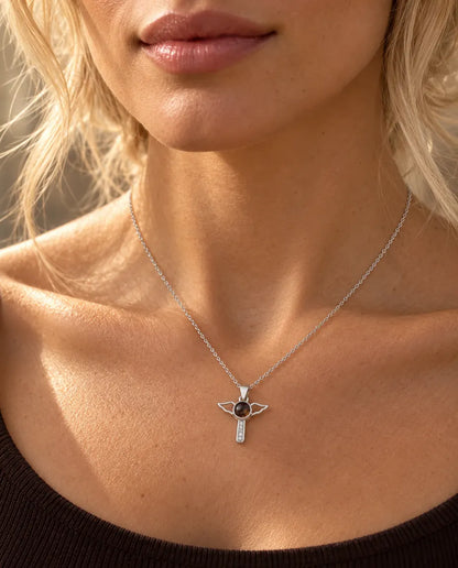 Femme en haut marron portant le collier croix aux ailes d'ange argenté