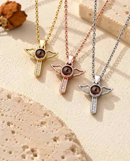 Croix ailées dorée, couleur or rose et argentée suspendues côte à côte