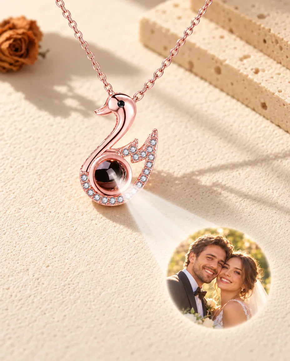 Collier cygne couleur or rose projetant une photo de mariage sur le plâtre