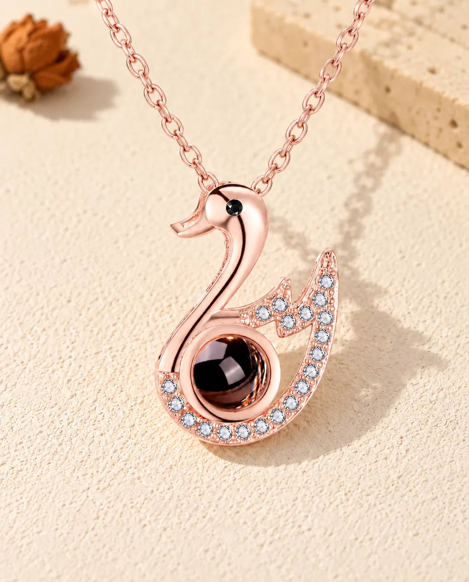 Vue de face du collier cygne couleur or rose avec photo dans la pierre