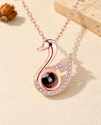 Vue de face du collier cygne couleur or rose avec photo dans la pierre