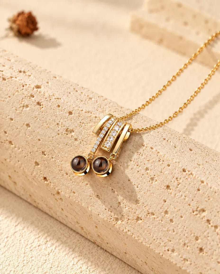 Pendentif doré serti de zircons avec deux pierres rondes sur du travertin