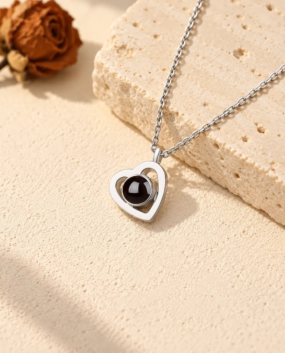 Collier photo projection double cœur en argent 925 sur du plâtre près d'un travertin