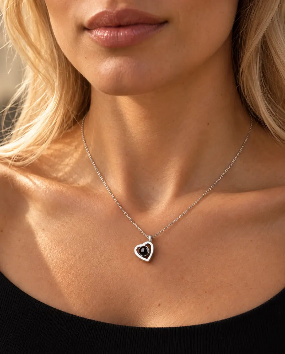 Femme en haut en maille noire portant le petit collier double cœur photo projection en argent