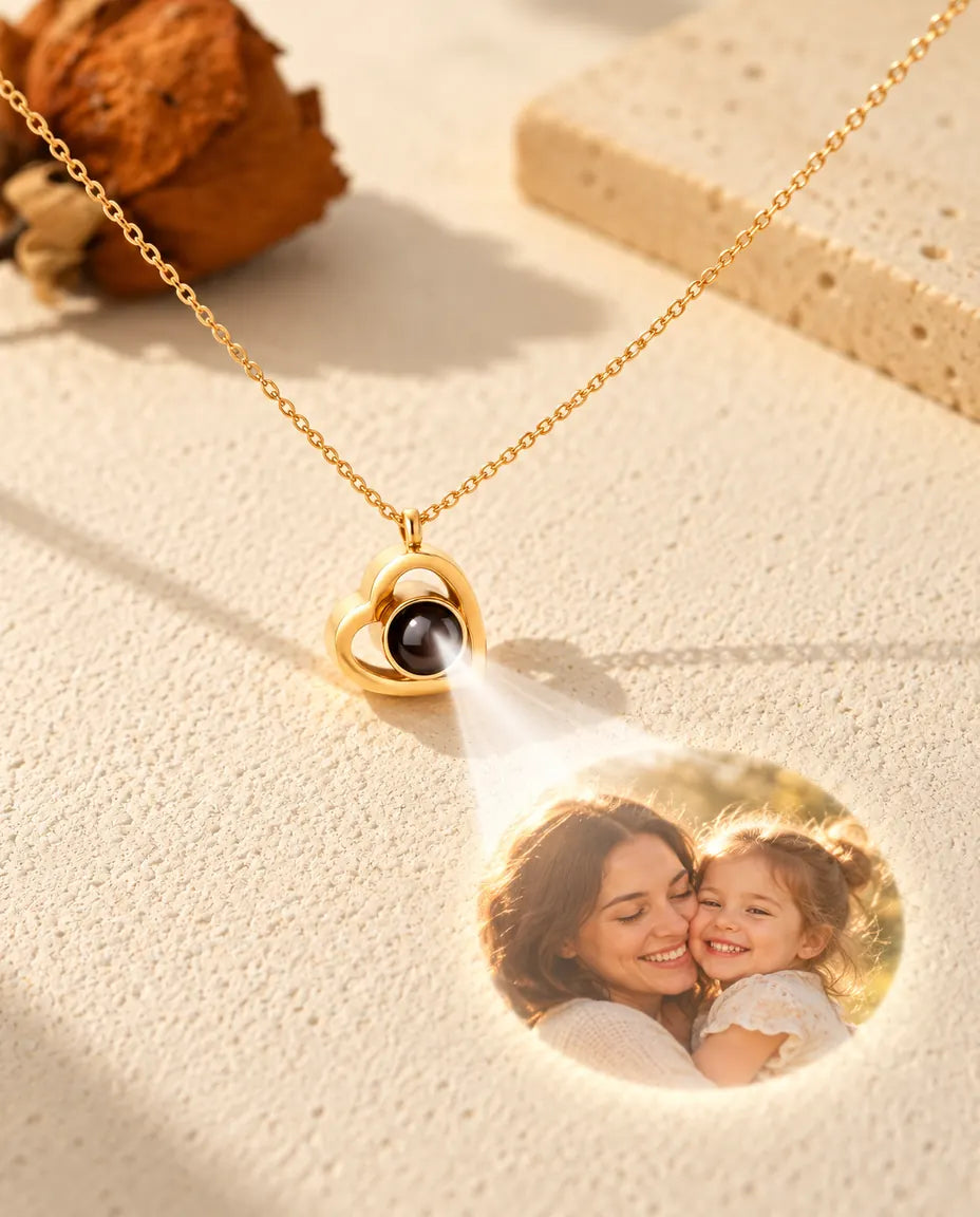 Collier double cœur doré projetant une photo de mère et fille sur du plâtre crème