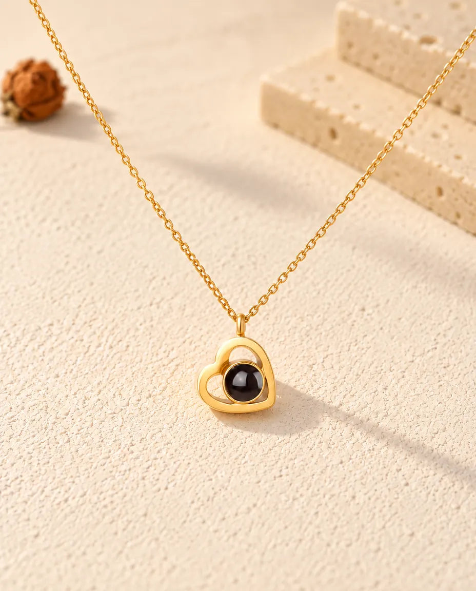 Pendentif double cœur doré vu de face avec sa pierre de projection sombre