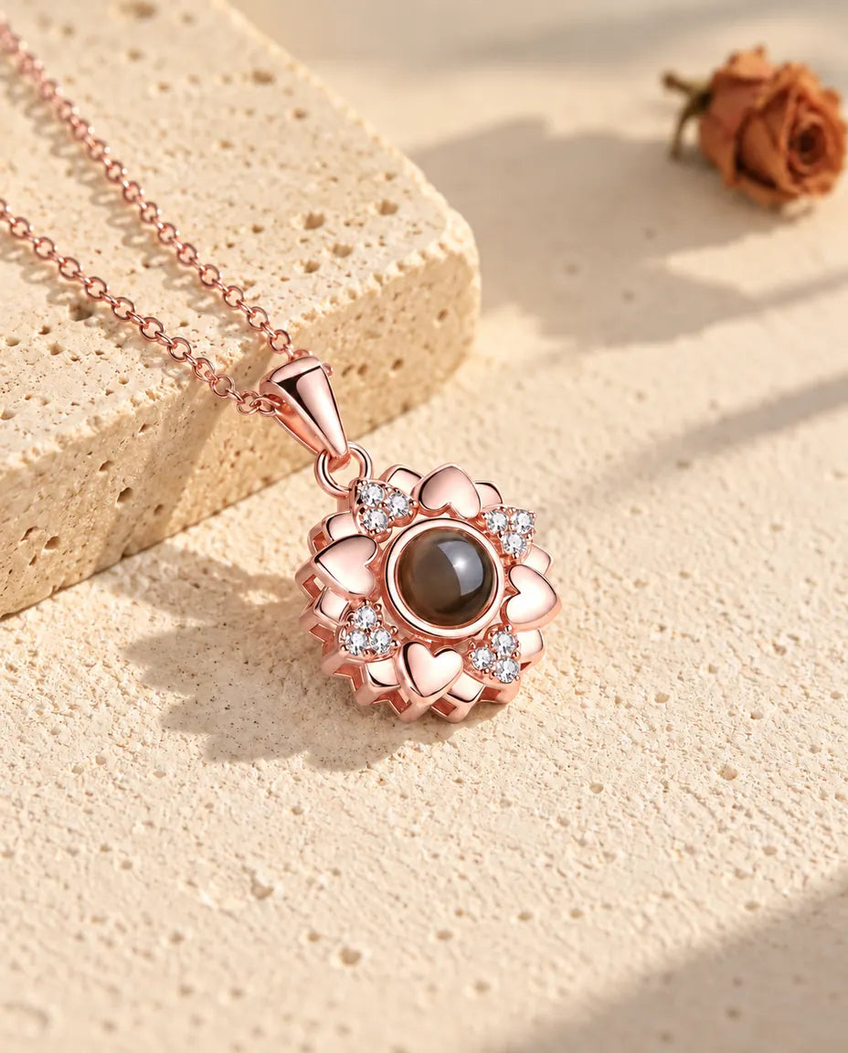 Collier fleur de cœurs couleur or rose sur le plâtre au soleil chaud