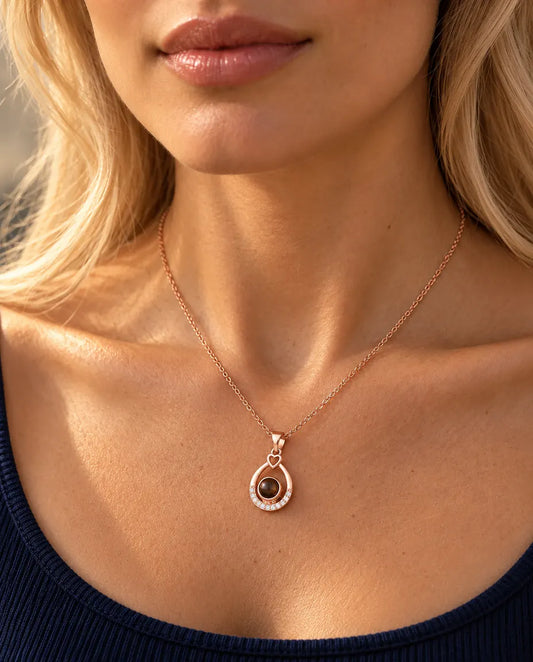 Femme en haut bleu marine portant le collier goutte ajourée couleur or rose