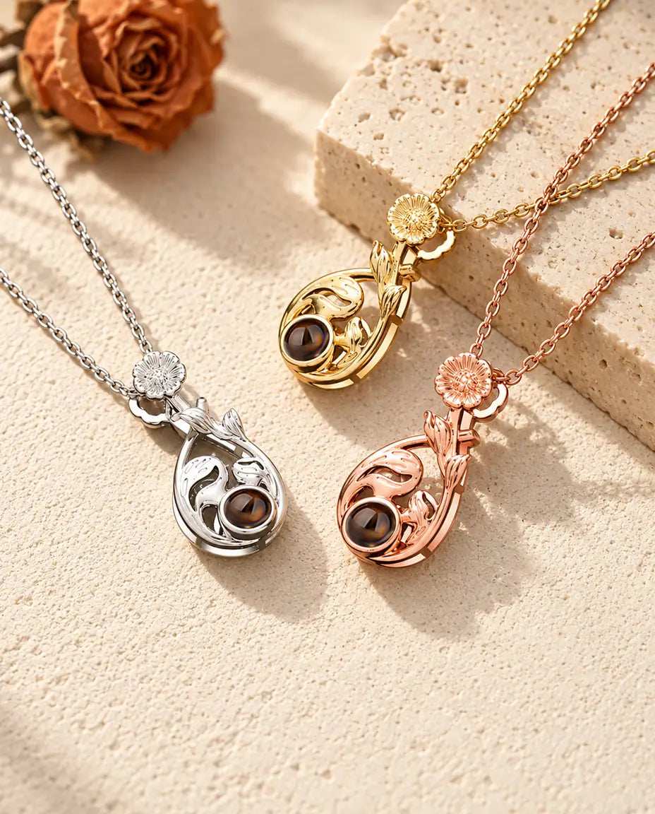 Pendentifs goutte argenté, doré et couleur or rose surmontés d'une marguerite sur du travertin