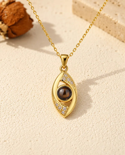 Vue de face du pendentif œil en amande doré dont l'iris est la pierre de projection