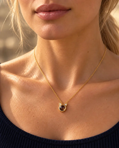 Femme en haut bleu marine portant le petit collier oreilles de chat doré