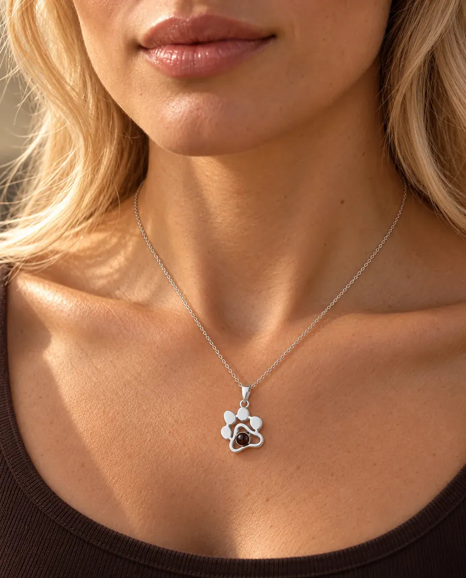 Femme en haut marron portant le collier patte argent avec photo dans la pierre