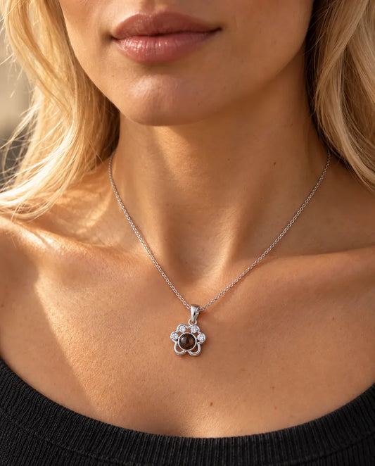 Femme en pull anthracite portant le collier patte argenté