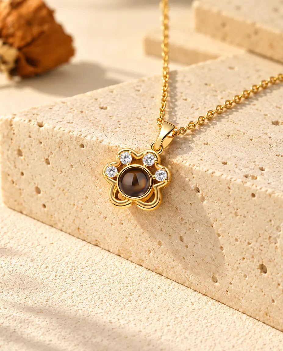 Collier patte doré posé sur du travertin