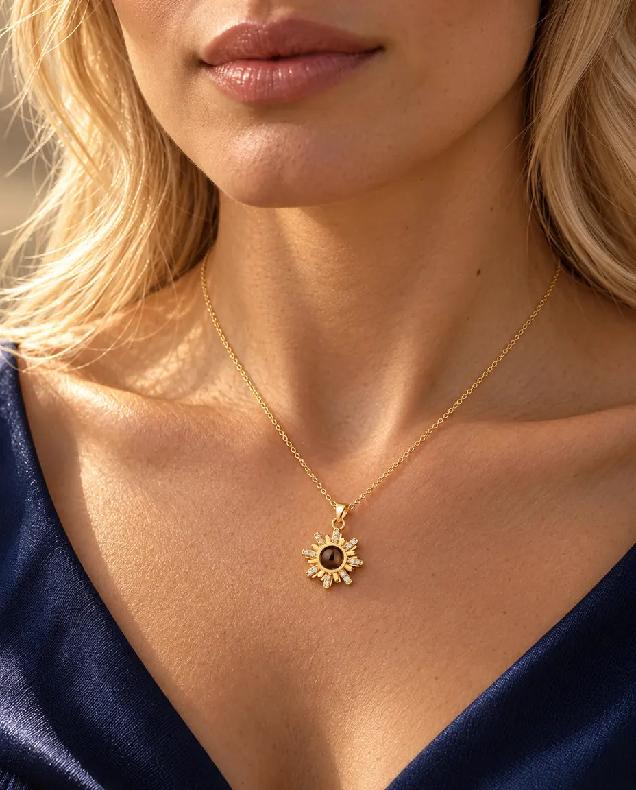 Femme en haut bleu marine portant le collier soleil doré avec photo dans la pierre