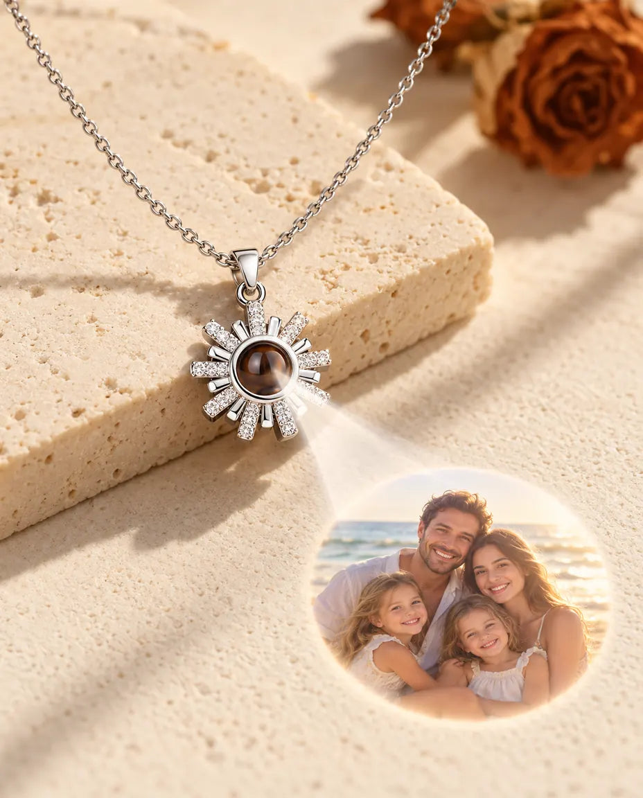 Collier soleil argenté projetant une photo de famille à la plage sur le plâtre crème
