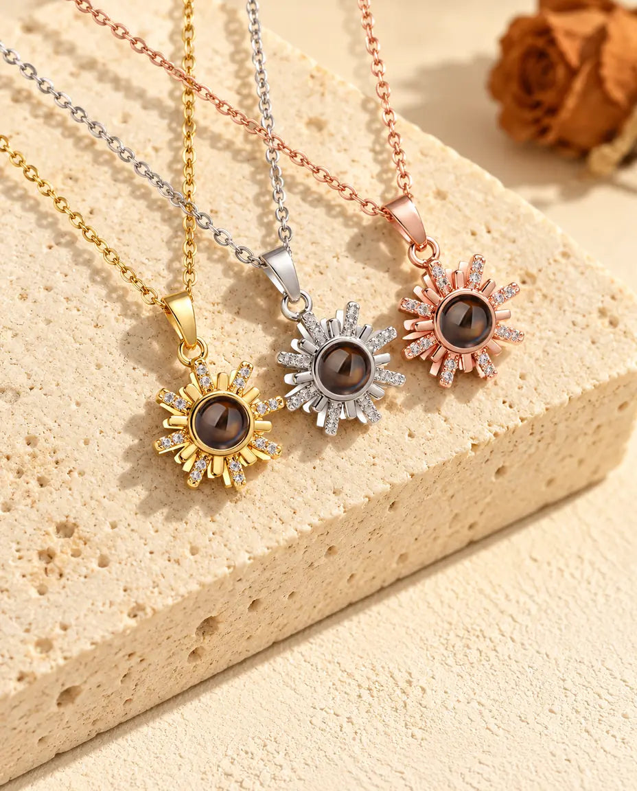 Pendentifs soleil doré, argenté et couleur or rose posés côte à côte