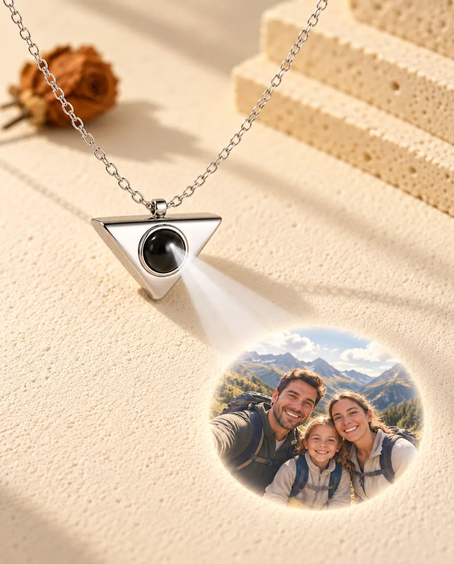 Collier triangle argenté projetant une photo de famille en randonnée sur le plâtre crème