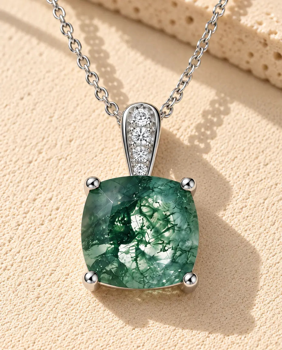 Collier Solitaire Agate Mousse en Argent 925 - posé sur une surface claire texturée près d’un bloc de travertin