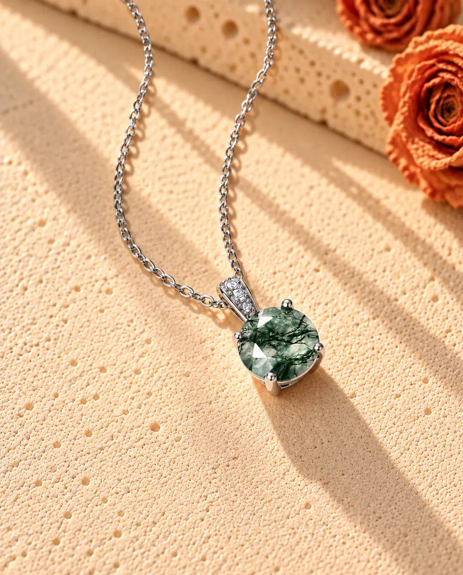 Collier Solitaire Agate Mousse Ronde en Argent 925 - vu de biais sur une surface claire texturée