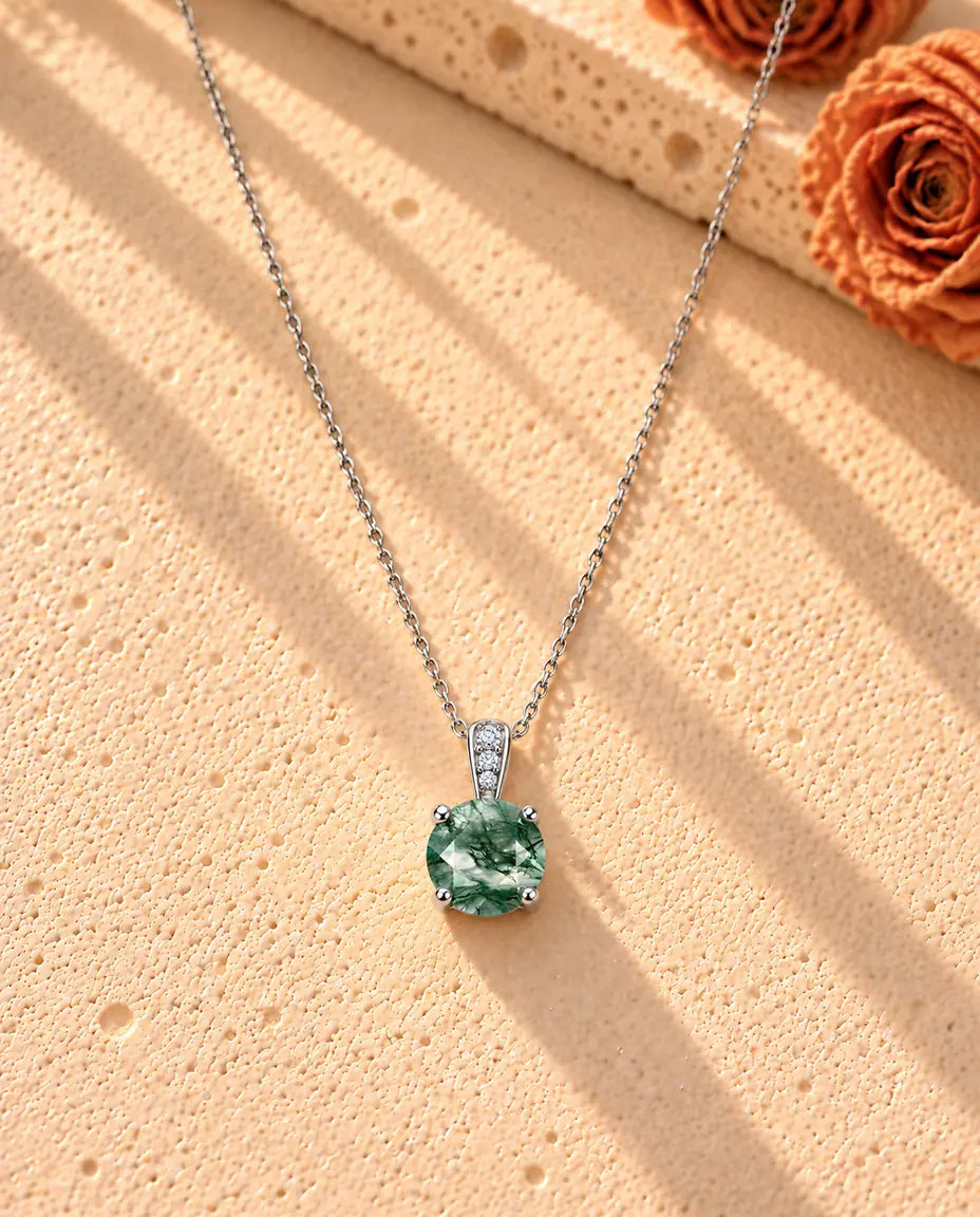 Collier Solitaire Agate Mousse Ronde en Argent 925 - le collier entier posé en long V sur une surface claire texturée