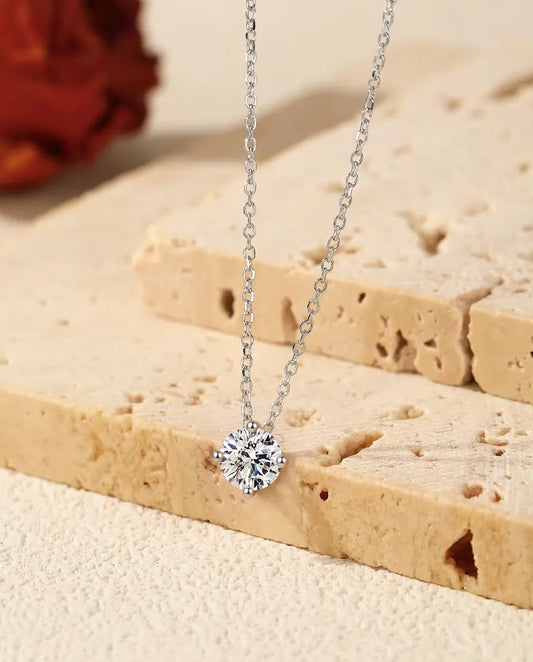 Collier Solitaire Moissanite 1 ct en Argent 925 - pendentif suspendu au rebord d’une dalle de travertin