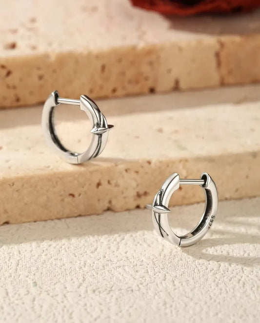 Boucles d’Oreilles Créoles Huggie Étoile en Argent 925 - la paire posée sur des marches en travertin