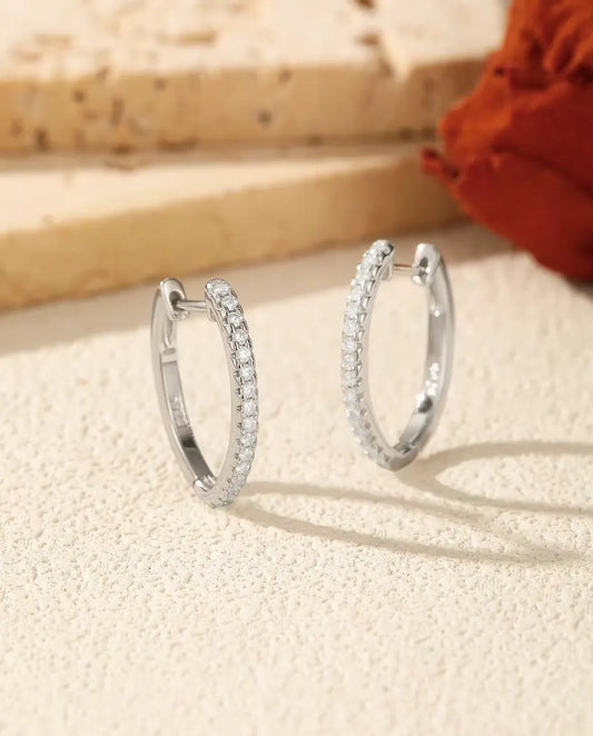 Boucles d’Oreilles Créoles Moissanite en U en Argent 925 - la paire posée côte à côte sur une surface claire texturée