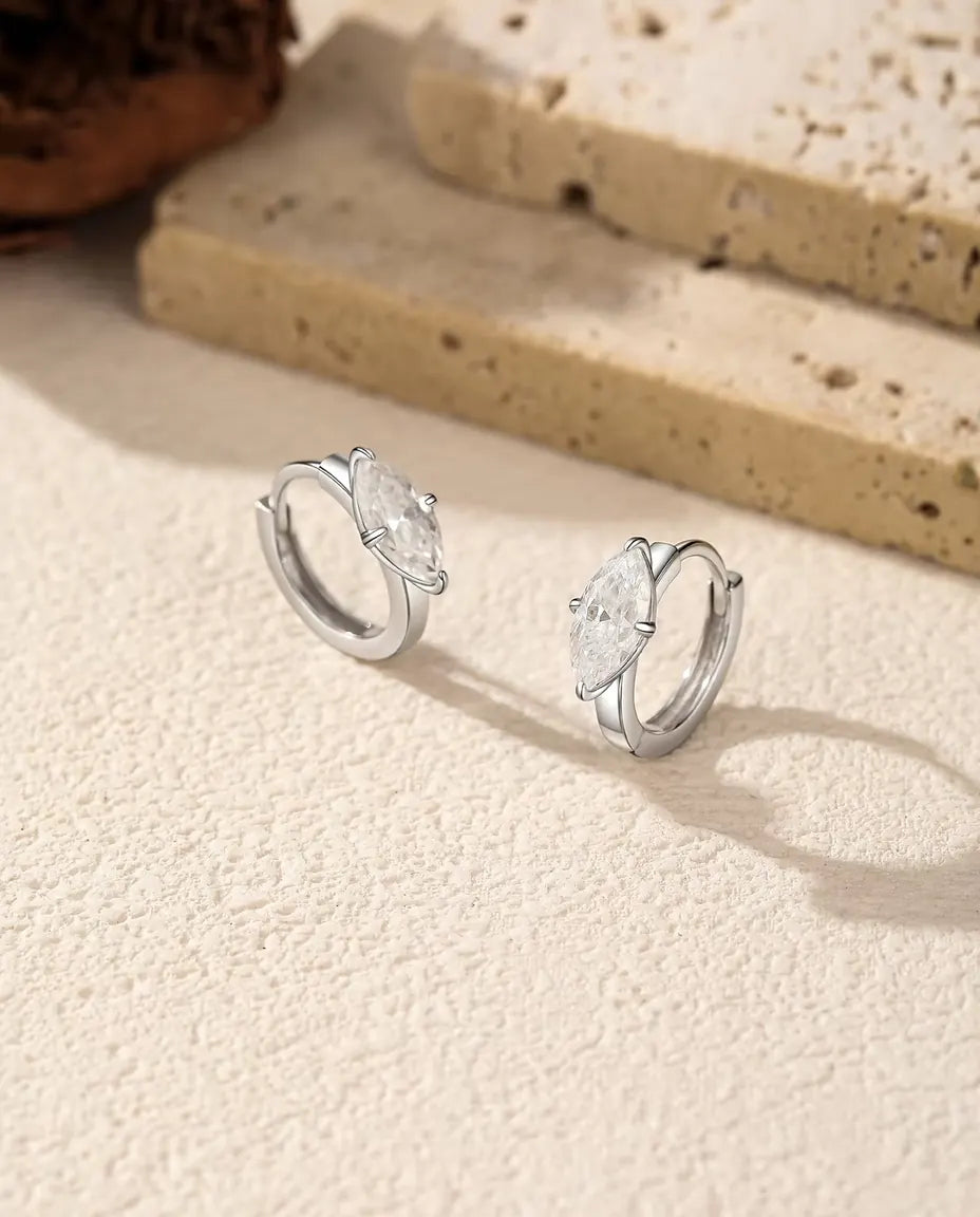Boucles d’Oreilles Créoles Moissanite en Argent 925 - la paire posée côte à côte sur une surface claire texturée