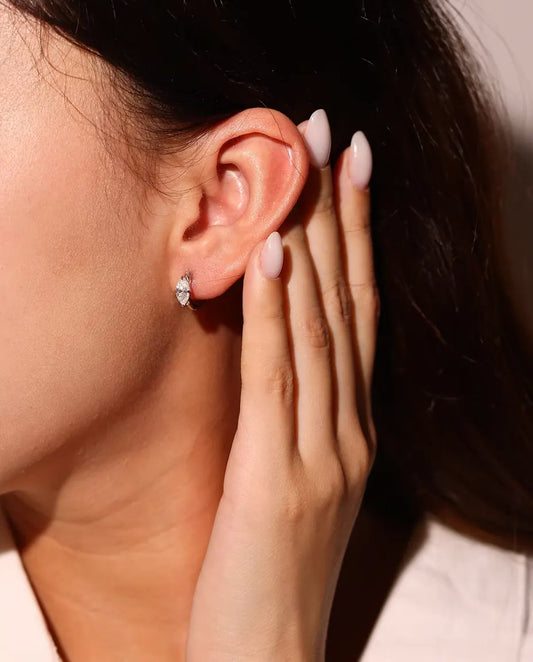 Boucles d’Oreilles Créoles Moissanite en Argent 925 - portées à l’oreille par un mannequin, main près du visage