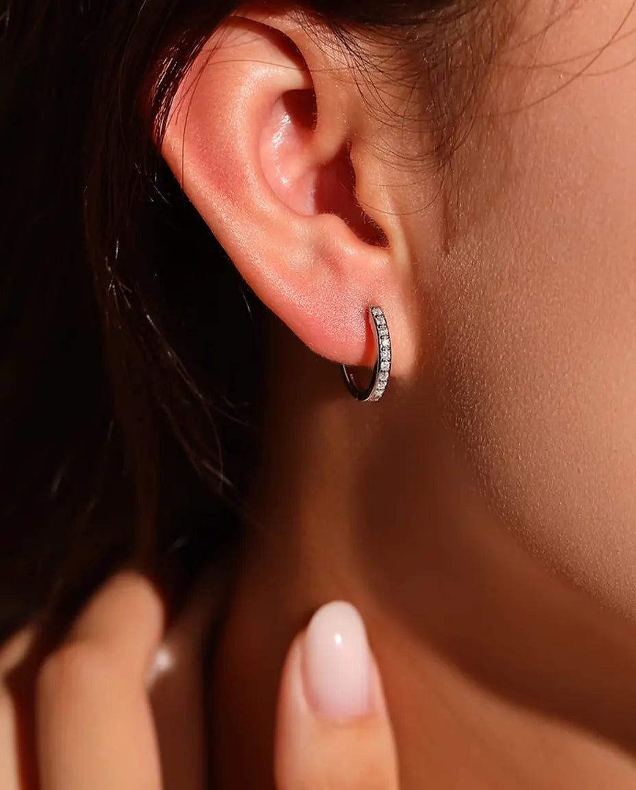 Boucles d’Oreilles Créoles Moissanite en Argent 925 - portées à l’oreille par un mannequin, main près du visage