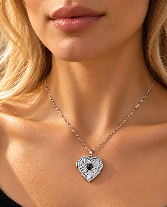 Femme en haut en maille noir portant le collier médaillon cœur arbre de vie argenté avec photo projection