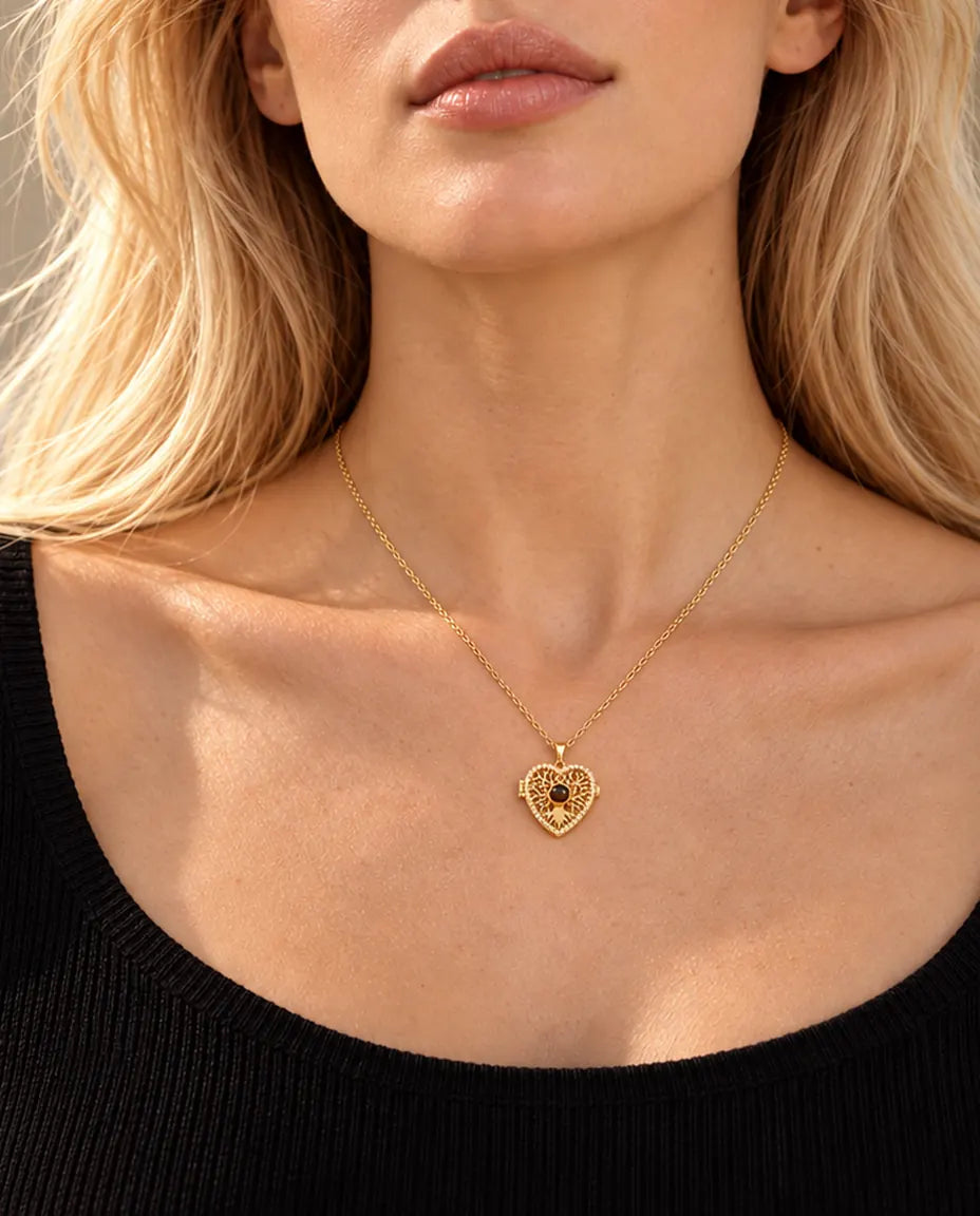 Femme blonde en haut noir portant le collier médaillon cœur arbre de vie doré avec pierre de projection